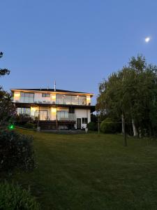 a large house with lights on in a yard at Incredible mountain & sea views in Mapua