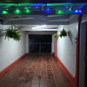 una habitación vacía con luces verdes y plantas en la pared en Pousada da Maria Guapa, en São Gabriel