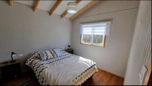 a bedroom with a bed and a window at Huella de Luna in Valdivia