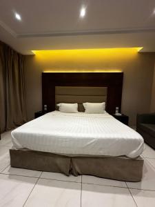 a bedroom with a large bed with white sheets at ورد للشقق المخدومة - احد رفيدة in Ahad Rafidah