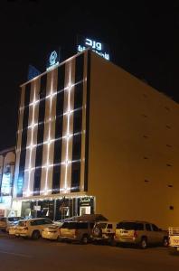 a large building with cars parked in front of it at ورد للشقق المخدومة - احد رفيدة in Ahad Rafidah