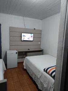 a bedroom with a bed and a flat screen tv at AP da val 3 no coração de Manaus in Manaus