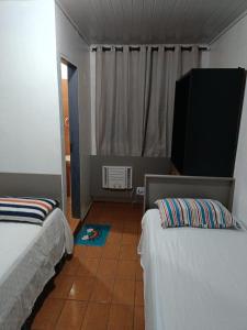 a room with two beds and a television in it at AP da val 3 no coração de Manaus in Manaus
