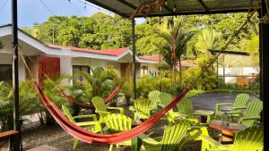 a hammock in a patio with chairs and tables at Kalunay Hostel - Breakfast included in Puerto Viejo +19 photos