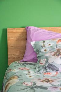 een bed met een paars kussen en een groene muur bij B&B Esotica in San Giovanni Teatino