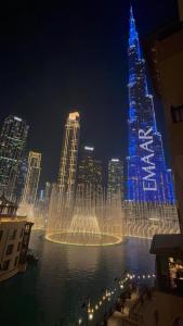 a water fountain in front of a city at night at Souk Al Bahar View Burj Khalifa and Fountains Dream View Holiday Homes in Dubai