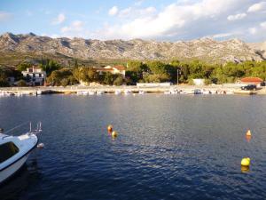 a boat in the water with mountains in the background at Apartments in Starigrad-Paklenica 35542 in Seline +8 photos