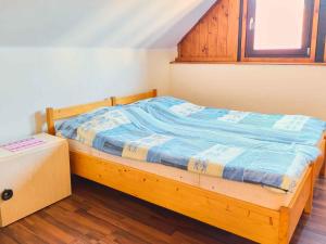 ein Holzbett in einem Zimmer mit Fenster in der Unterkunft Holiday home Balatonbereny - Balaton 18113 in Balatonberény