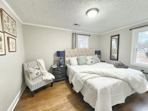 a bedroom with a bed and a chair and a window at Stylish 2BR in Decatur - Big Deck - Pets OK - Fire Pit in Decatur