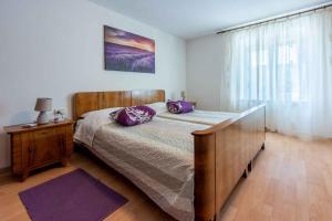 DomijančićiHoliday home in Drivenik 41881的一间卧室配有一张带紫色枕头的床 更多37张照片