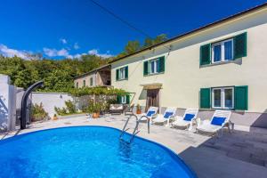 DomijančićiHoliday home in Drivenik 41881的带椅子的游泳池和一栋房子