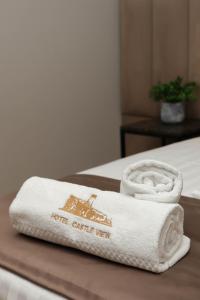 a pile of towels sitting on top of a bed at Hotel Castle View in Krujë