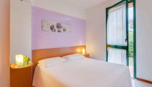 a bedroom with a white bed and a window at Apartment in Follonica - Toskana 44106 in Casa SantʼEugenia