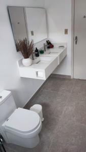 a bathroom with a white toilet and a sink at Pousada Mahalo in Guarujá +44 photos