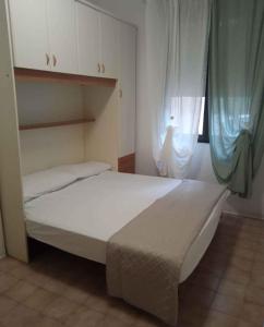 a bedroom with a white bed with a window at One-Bedroom Apartment in Rosolina Mare V in Rosolina Mare
