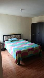 - une chambre avec un grand lit et un couvre-lit coloré dans l'établissement Judith Milka, à Chiclayo