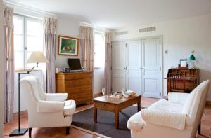 - un salon avec des chaises blanches et une table basse dans l'établissement Auberge Ostapé, à Bidarray