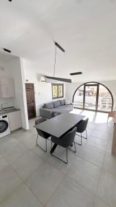 een grote woonkamer met een tafel en stoelen bij Villa Sotavento Ocean Views Modern New Apartment in Natural Park in Playa Jandia