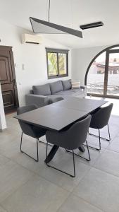 een woonkamer met een tafel, stoelen en een bank bij Villa Sotavento Ocean Views Modern New Apartment in Natural Park in Playa Jandia +16 foto's