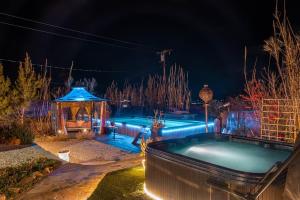 约书亚树Casa Luisa Joshua Tree的游泳池,在晚上设有凉亭