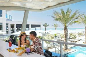 a man and a woman sitting at a table with food at Renaissance Daytona Beach Oceanfront Hotel in Daytona Beach