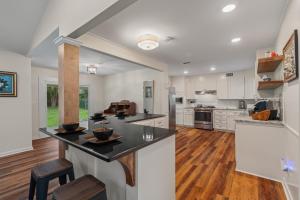 ハッティーズバーグにあるMagnolia Retreatの白いキャビネットと黒いカウンタートップを備えたキッチン