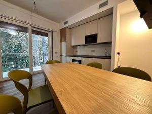 a kitchen with a wooden table and green chairs at Apartment in Rosolina Mare 54758 in Rosapineta