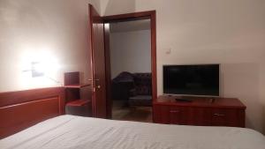a bedroom with a bed and a flat screen tv at Lux apartman in Banja Luka