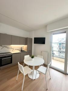 una cucina con un tavolo bianco e sedie in una stanza di Lanterna View Apartment - Sea View a Genova