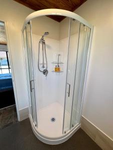 a shower with a glass enclosure in a bathroom at Pinewood Motels in Fairlie +38 photos