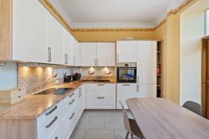 Una cocina con gabinetes blancos y una mesa de madera. en Cozy 3BR Townhome Walk to City Center & Park Free, en Luxemburgo