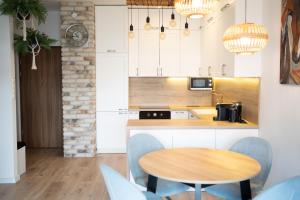 a kitchen with a wooden table and blue chairs at Perfect View II - idealny widok na Marinę in Iława