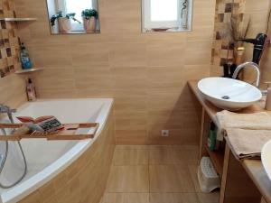 a bathroom with a bath tub and a sink at Holiday home in Balatonlelle 54843 in Balatonboglár Vasútállomás