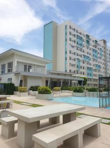 a large building with benches in front of a building at Kaira's Condo at Marina Spatial 2 BR WIFI Netflix in Laguna
