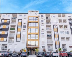 an apartment building with cars parked in front of it at Apartman Blue in Subotica