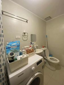 a bathroom with a washing machine and a toilet at Kaira's Condo at Marina Spatial 2 BR WIFI Netflix in Laguna