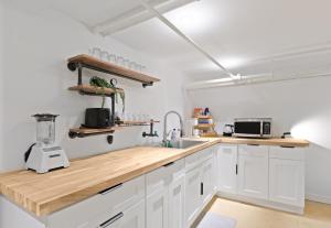a kitchen with white cabinets and a wooden counter top at 20 Mins to Times Sq. EWR | Cozy Apartment | Sleeps 4 in Jersey City +22 photos