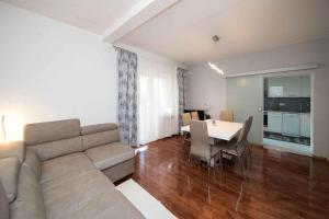 a living room with a couch and a table with chairs at Apartment in Crikvenica 41676 in Sopaljska