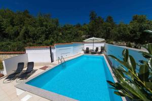 a swimming pool on a patio with chairs around it at Apartment in Crikvenica 41676 in Sopaljska