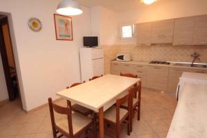 a kitchen with a table and chairs and a refrigerator at Apartment in Rosolina Mare 25040 in Rosapineta