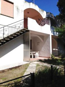 a white building with a balcony and a table at Apartment in Rosolina Mare 25040 in Rosapineta