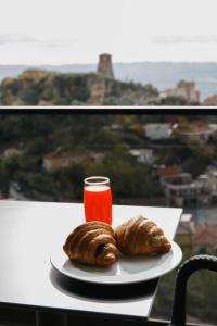 a plate with two croissants and a drink on a table at Hotel Castle View in Krujë