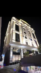 a large white building with lights on it at night at Central location in the city center, two-room apartment in Baljurashi