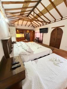 een kamer met drie bedden en een televisie. bij Apartamento Colonial in Estación El Salto