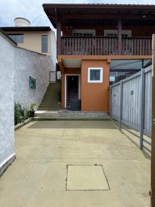 een huis met een patio en een balkon bij Chalé 2 em Ilhabela in Ilhabela