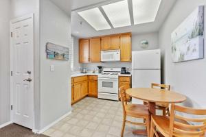 a kitchen with a table and a white refrigerator at Coastal Cutie in Oceano