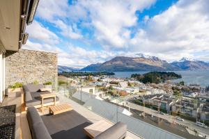 einen Balkon mit Blick auf das Wasser und die Berge in der Unterkunft Luxury Away - Manaia Views-HotTub-FreeParking-BBQ in Queenstown