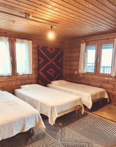 a room with two beds in a wooden cabin at 海を眺めるログハウス カマカーマAwaji in Awaji