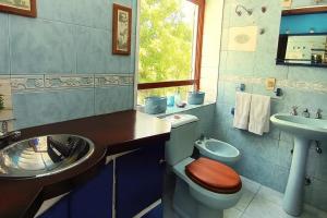 ein Badezimmer mit Toilette, Waschbecken und Spiegel in der Unterkunft Casa Gloria con Piscina - Jacuzzi exterior climatizada Relax Playa in Punta del Este + 27 Fotos