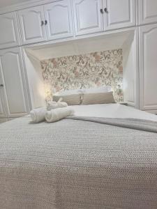 un lit blanc avec un animal rembourré au dessus dans l'établissement Piso céntrico Corazón de Aridane, à Los Llanos de Aridane